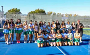 High school girls' sports team posing confidently on a field.