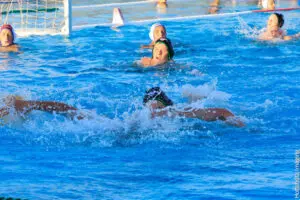 Water polo players competing intensely in a pool.