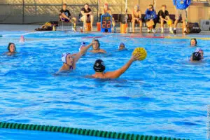 Water polo players compete intensely in a pool during a match.