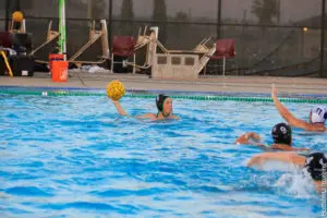 Athlete prepares to throw ball in water polo match.