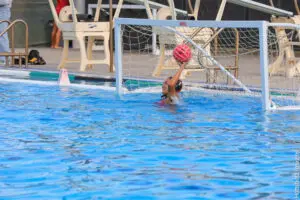 Water polo goalkeeper ready to block a shot in the pool.