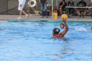 Water polo player preparing to throw the ball in a pool.