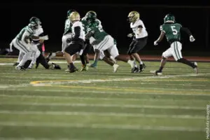 Football players in action during a night game on the field.