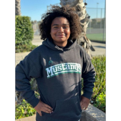 A person smiling outdoors in a Mustang sweatshirt.