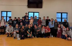 A large group of people posing indoors, smiling at the camera.