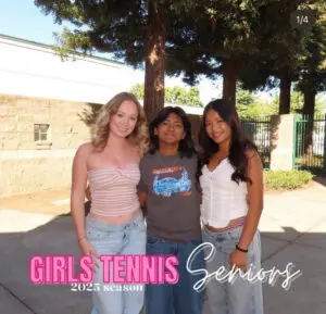 Three senior girls posing outdoors for tennis team photo.