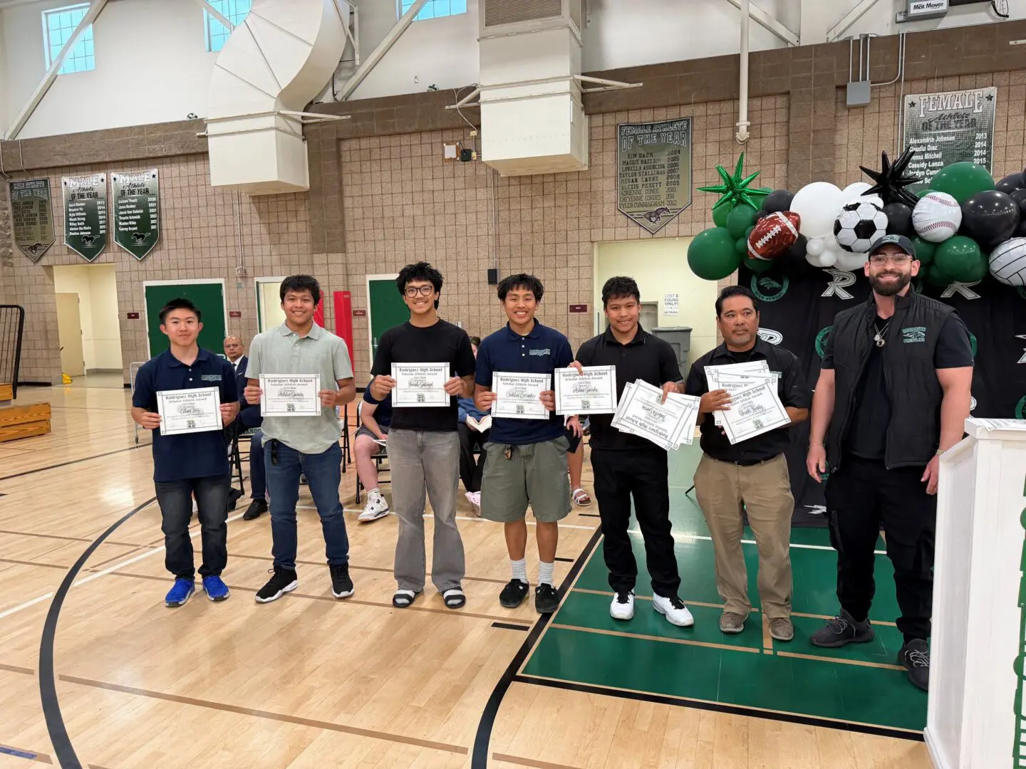 Students holding awards in a gym
