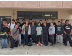 A group of young people posing together outside a building.