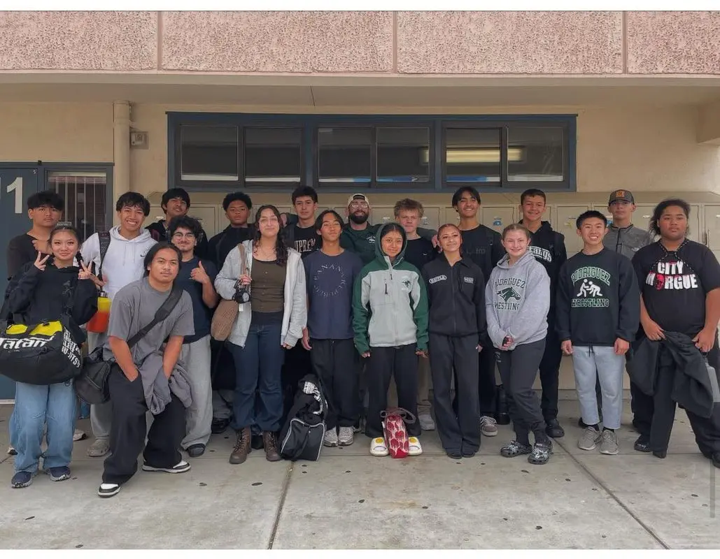 A group of young people posing together outside a building.