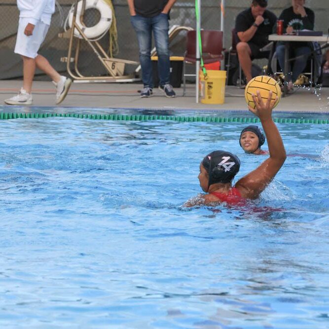 Water polo player preparing to throw the ball in a pool.