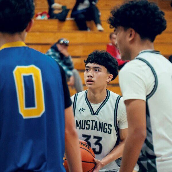 High school basketball players focused during a game.