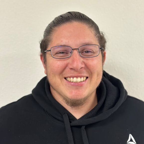 Smiling person wearing glasses and hoodie