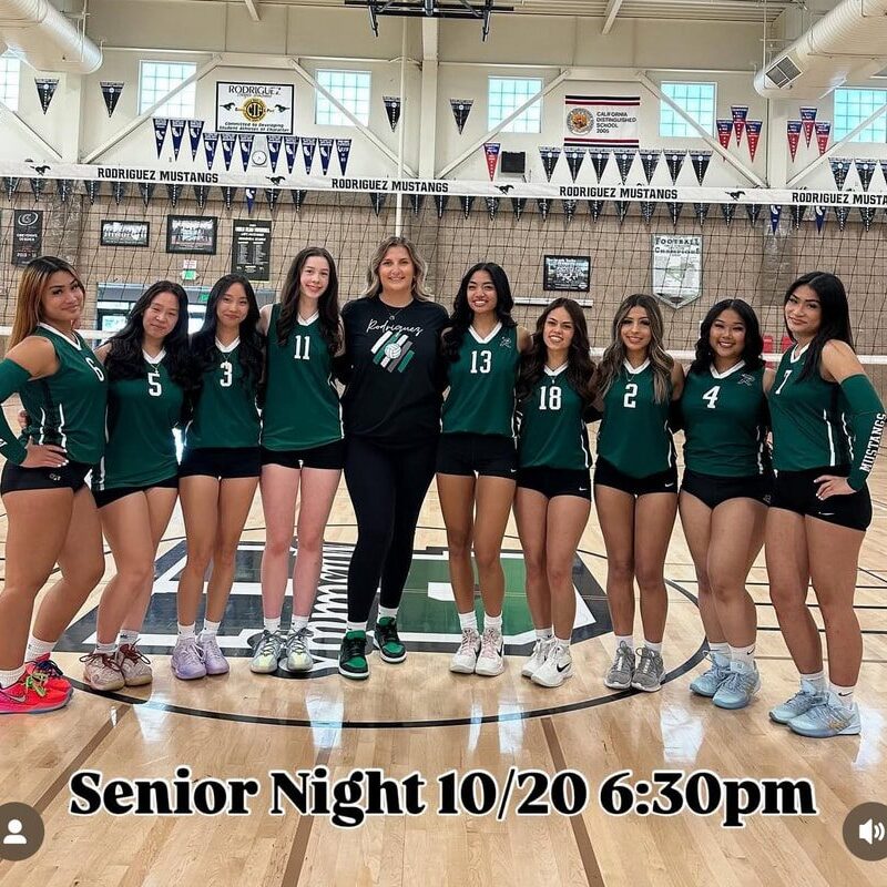 Girls' volleyball team posing on Senior Night in their uniforms.